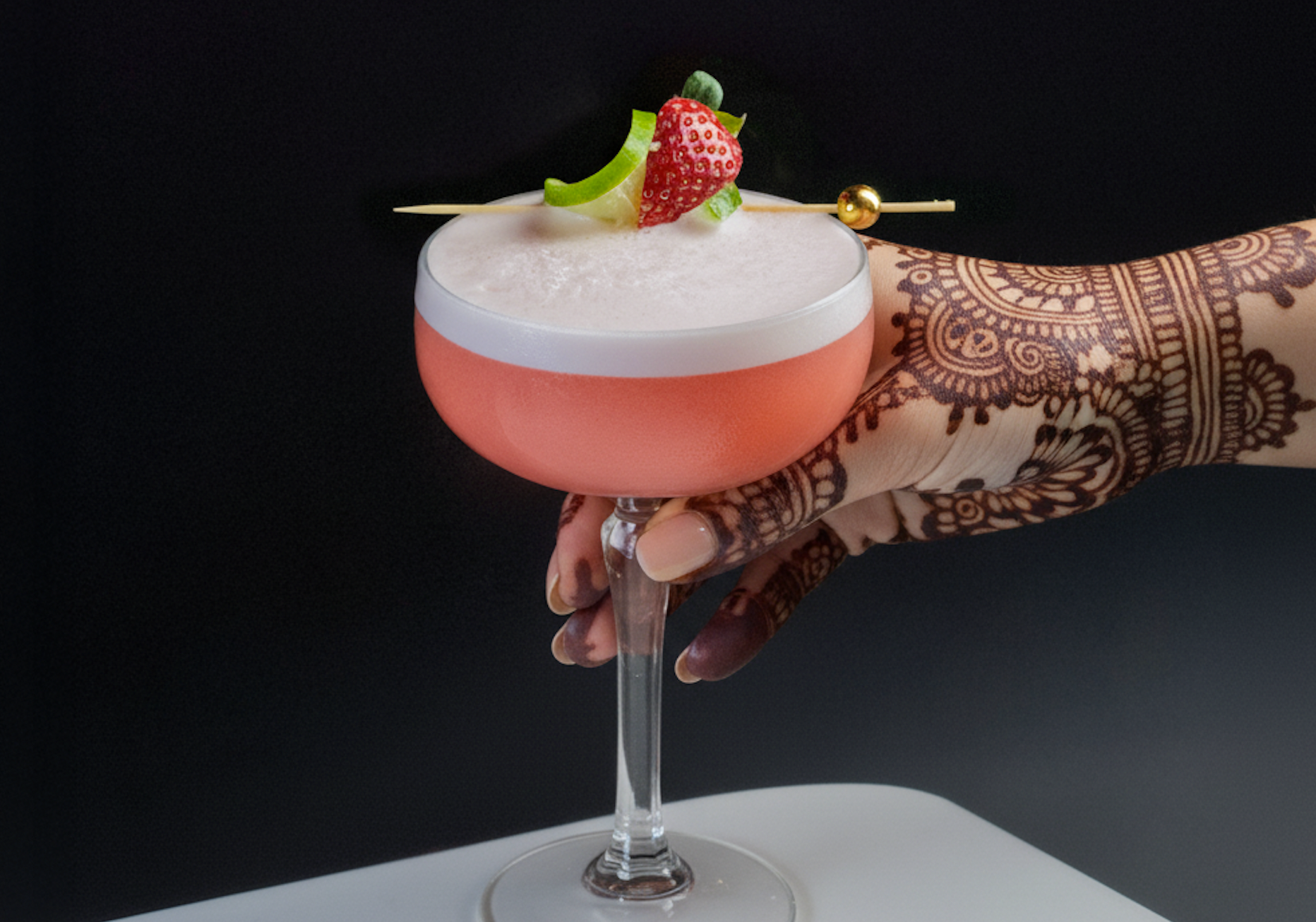 a hand with henna and a cocktail