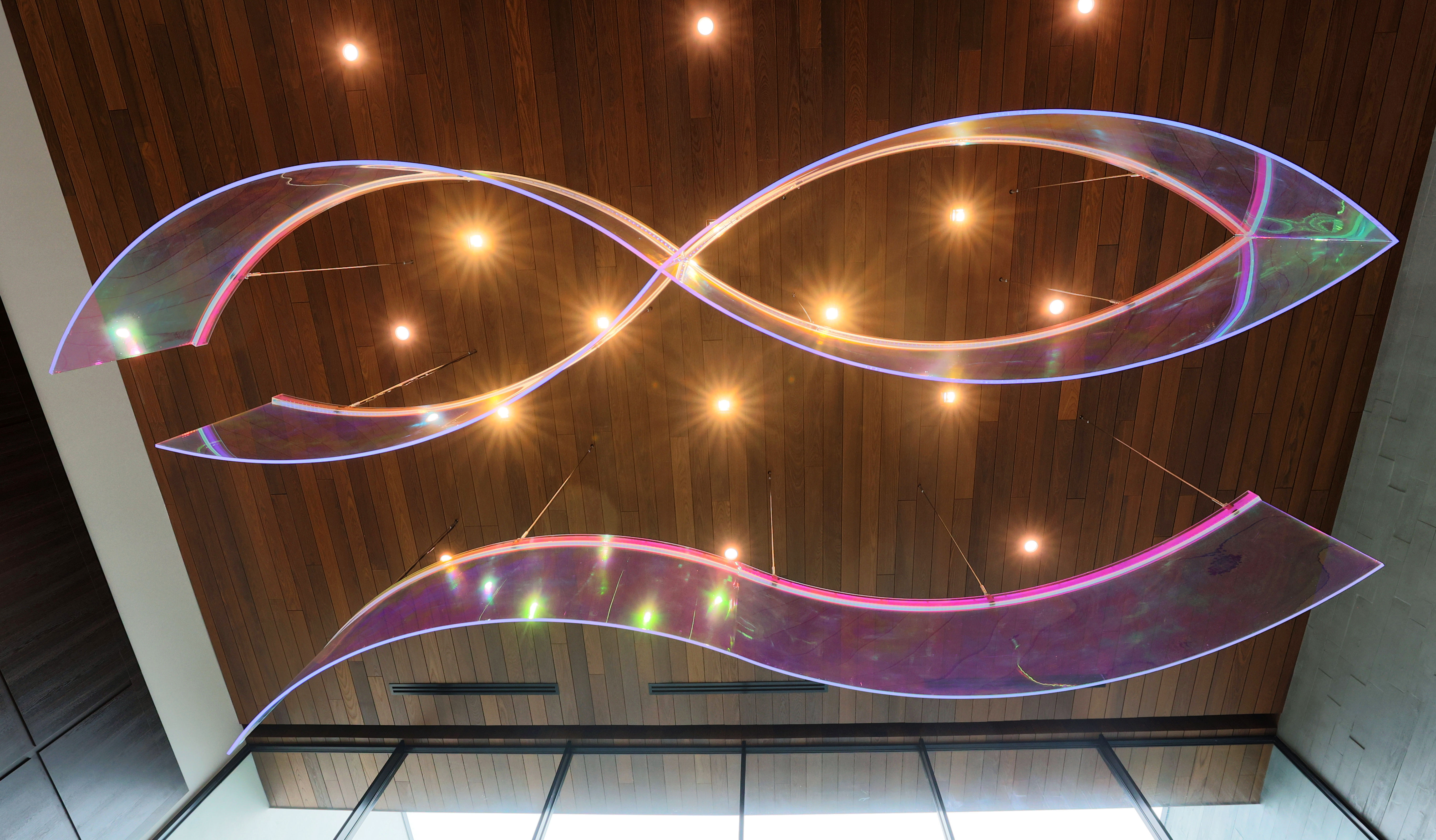 The ribbon-like acrylic chandelier and art piece was created by...