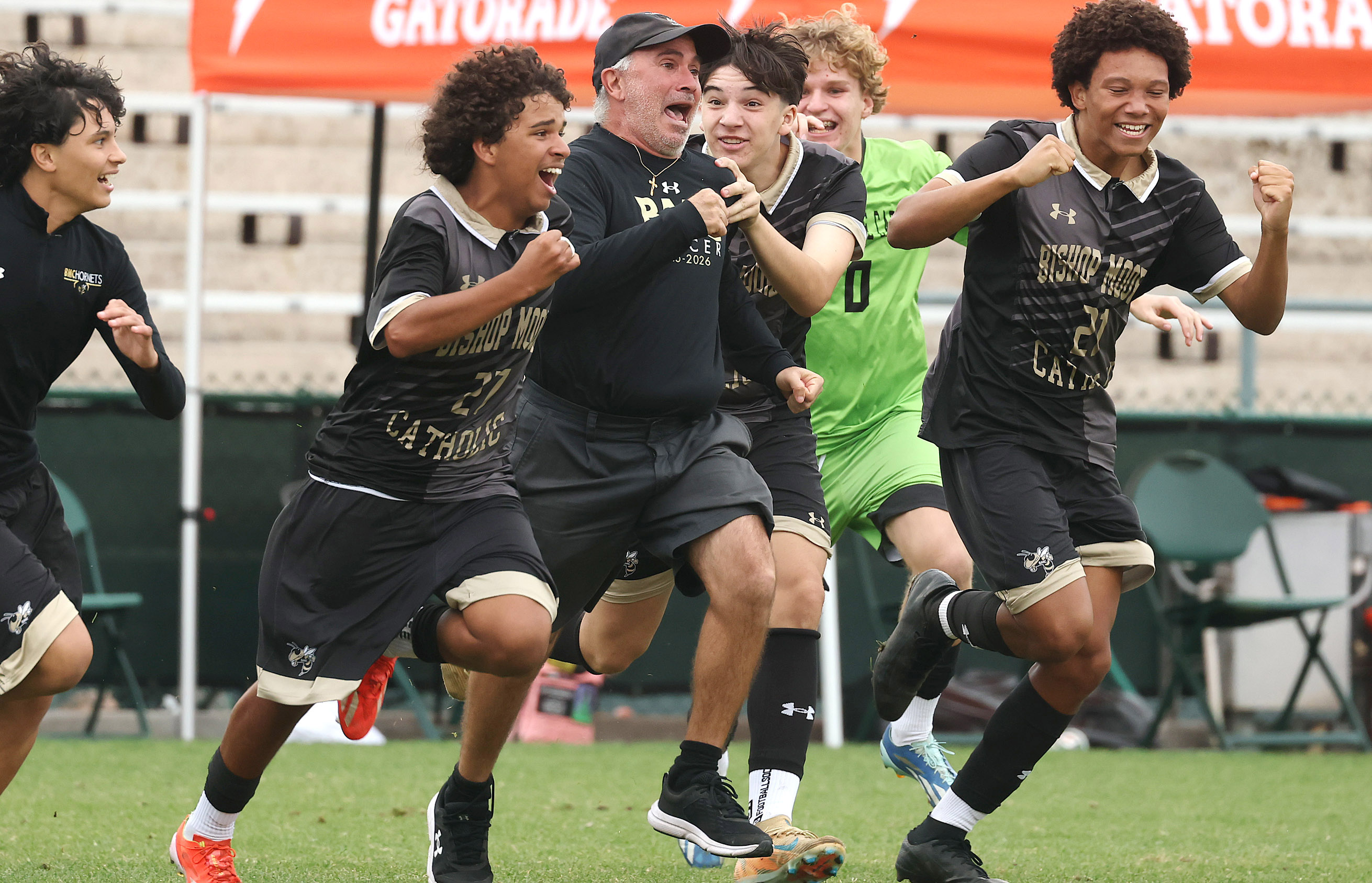 Bishop Moore Catholic High School soccer coach Tom Hage (middle)...