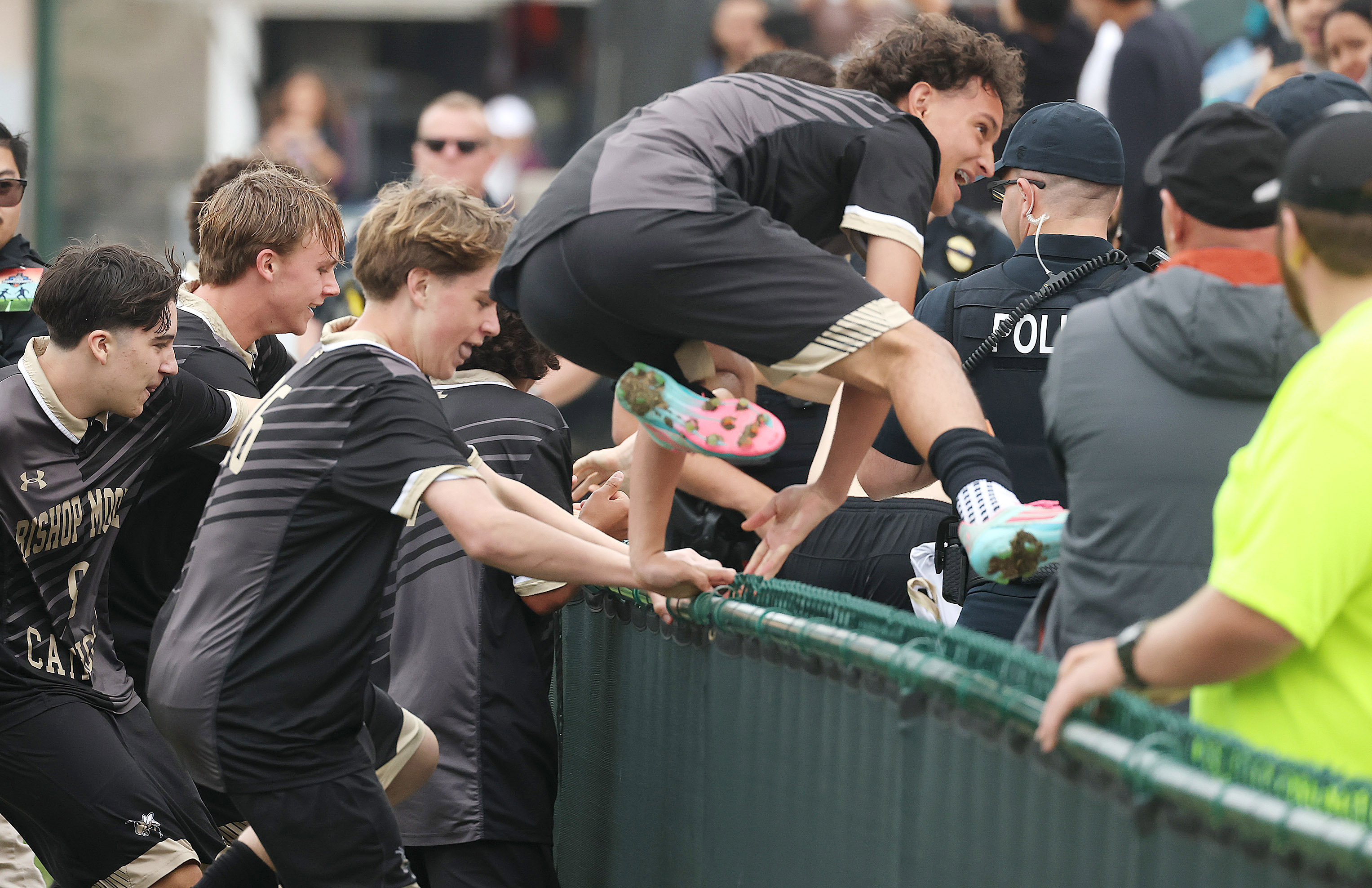 Bishop Moore Catholic High School soccer players leap over the...