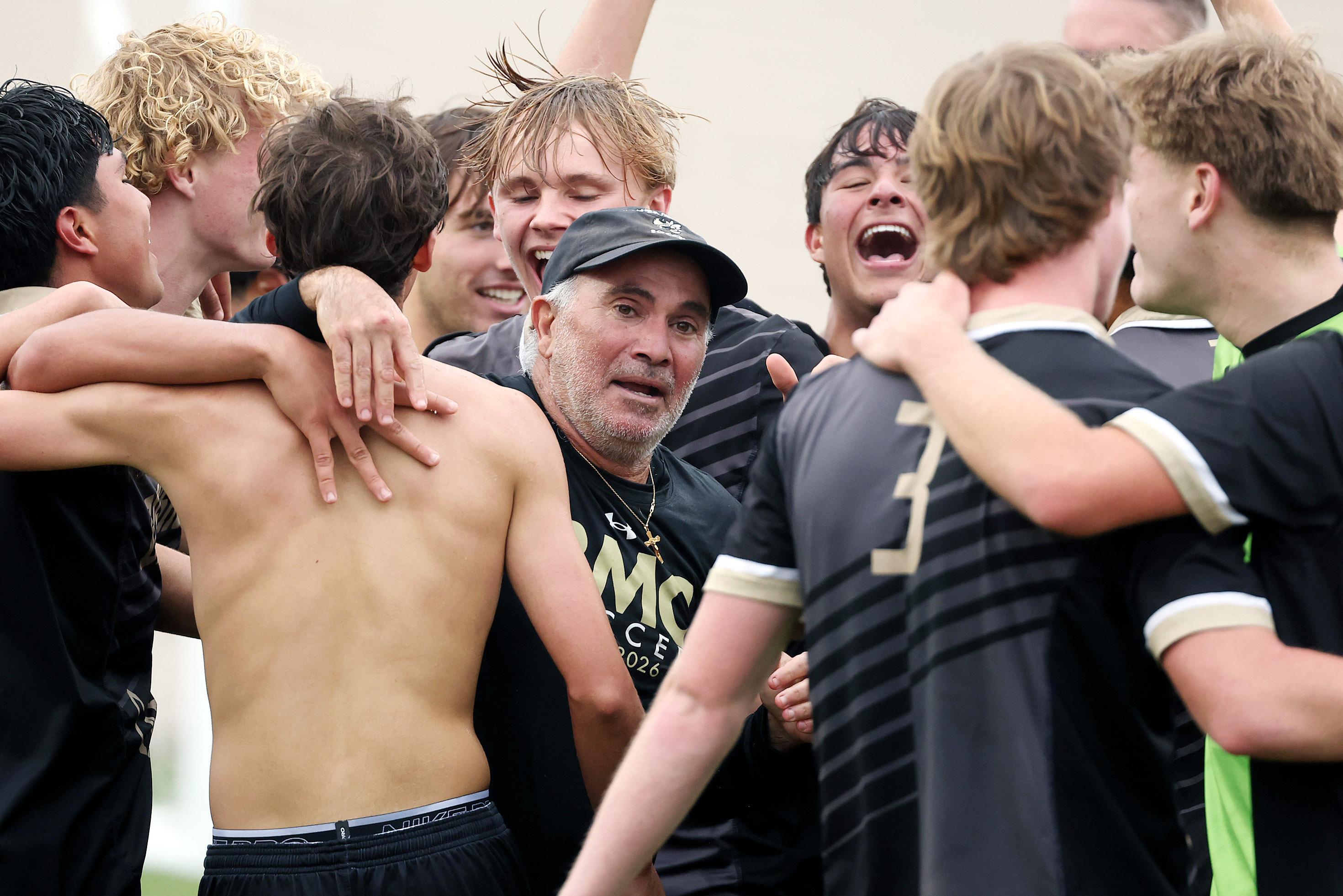 Bishop Moore Catholic High School soccer players celebrate with coach...