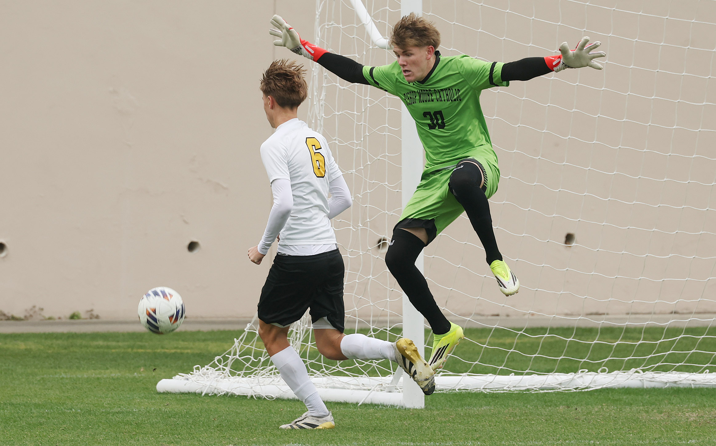 Bishop Moore Catholic High School goalkeeper Colin Norton (30) spreads...