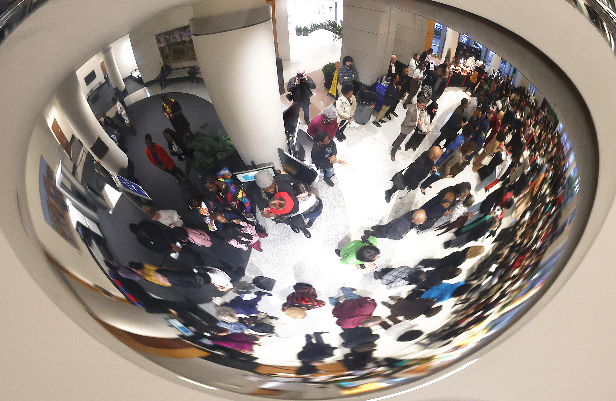 The crowd is viewed in the reflection of a security...