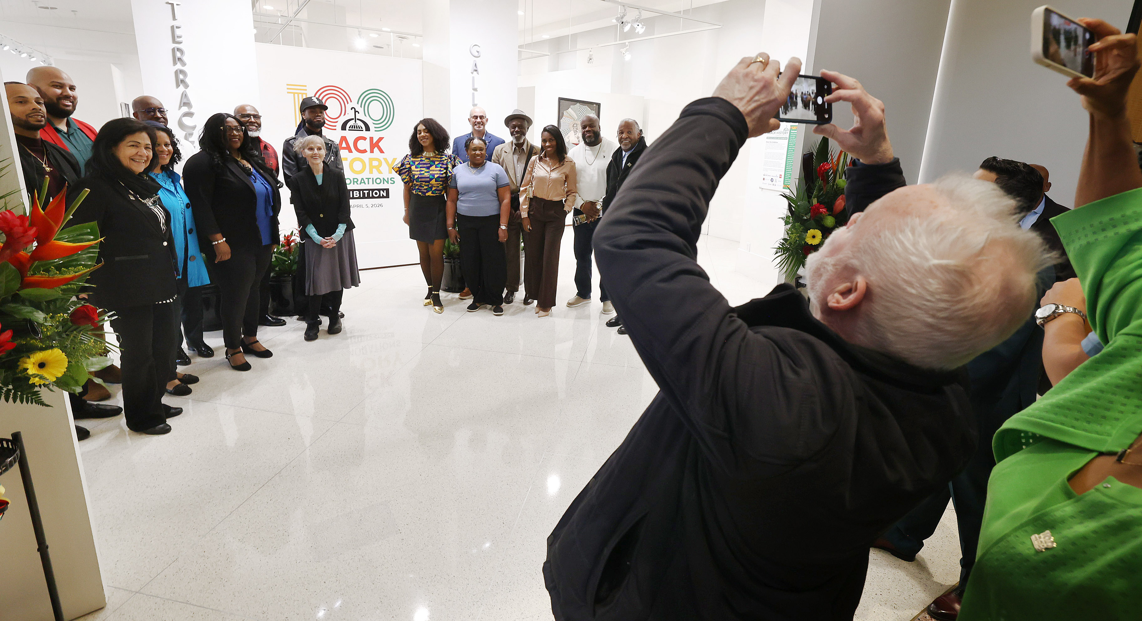 Visitors take photos of some of the artists during the...