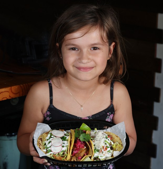 Lily Calloway, 7, holds a plate of tacos at Black Rooster Taqueria ... but she's actually a self-proclaimed guac conoisseur. (Stephen M. Dowell/Orlando Sentinel)