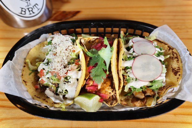 The Chicken Tinga, Achiote Pork, and Smoked Beef Brisket Tacos at Black Rooster Taqueria in Orlando. (Stephen M. Dowell/Orlando Sentinel)