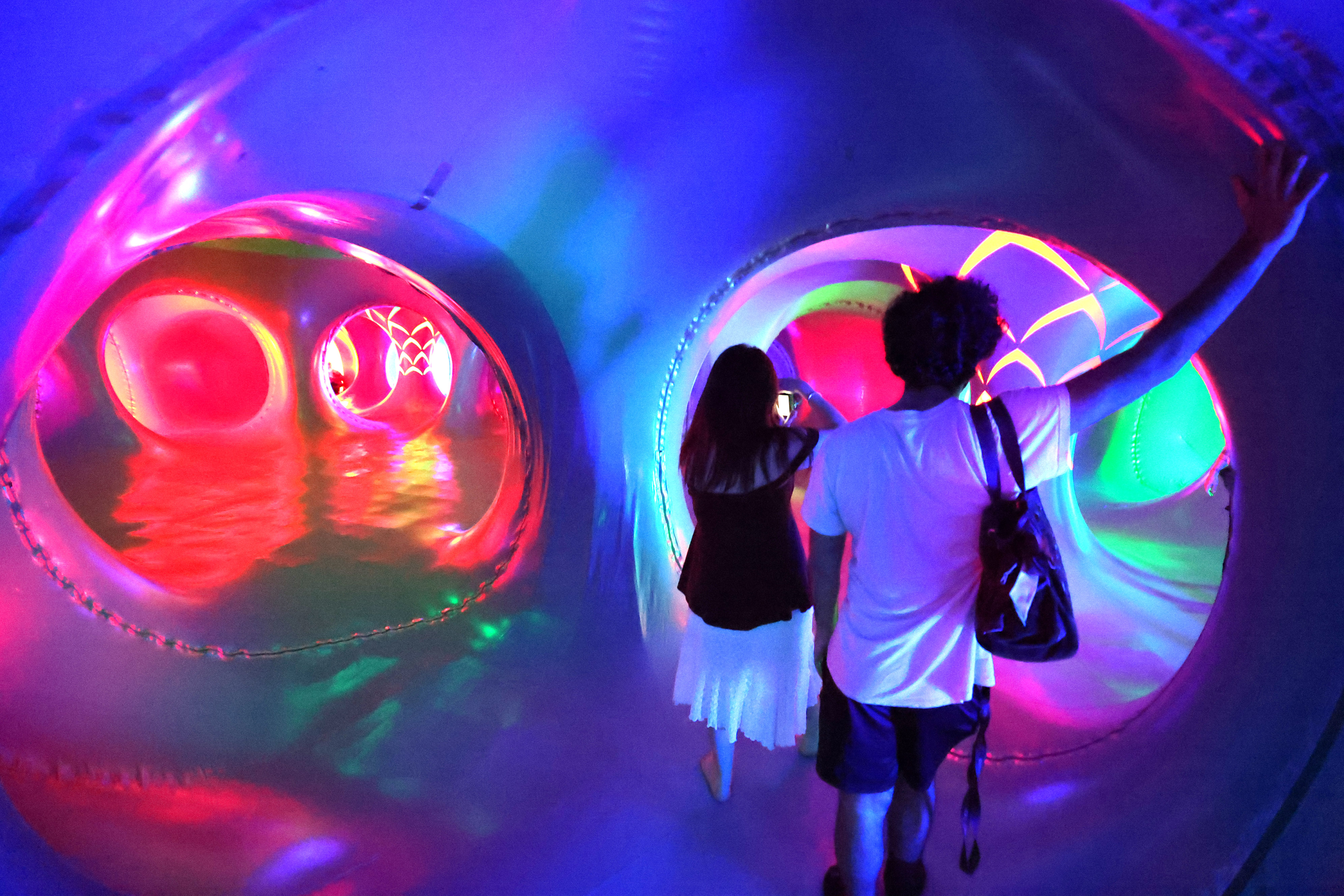 Attendees wander inside the Architects of Air Arborialis Luminarium during...