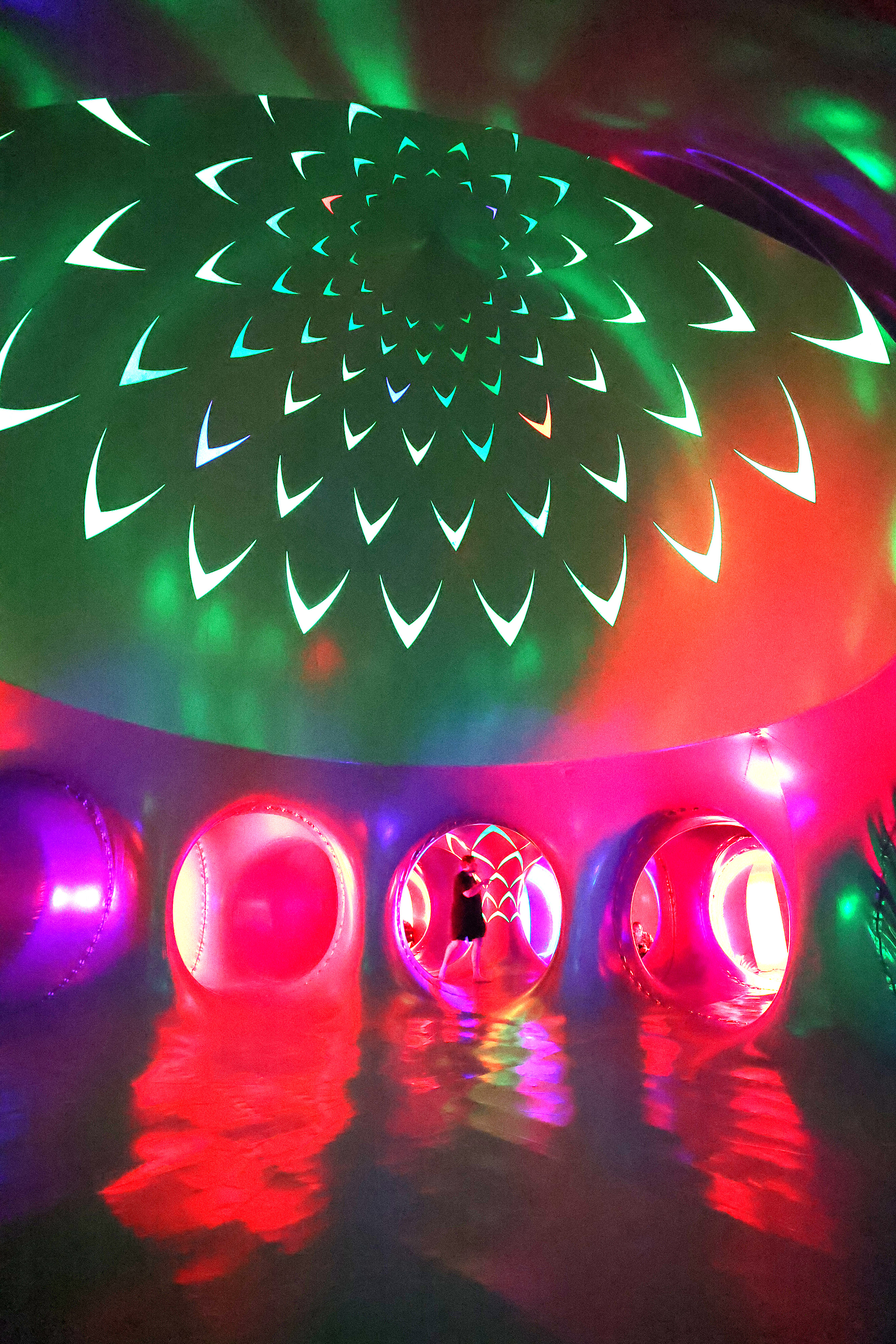 Attendees wander inside the Architects of Air Arborialis Luminarium during...