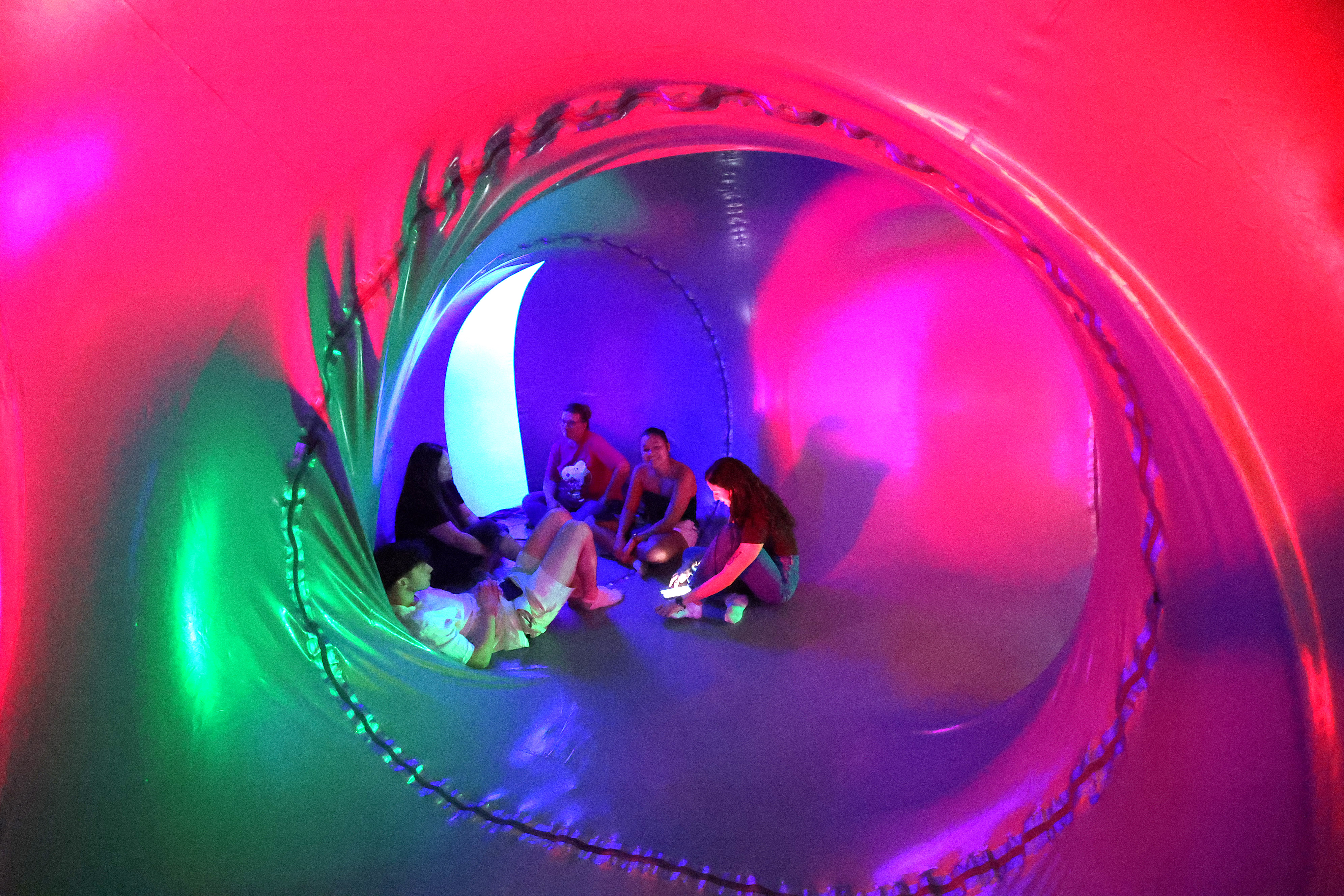 Attendees relax inside the Architects of Air Arborialis Luminarium during...