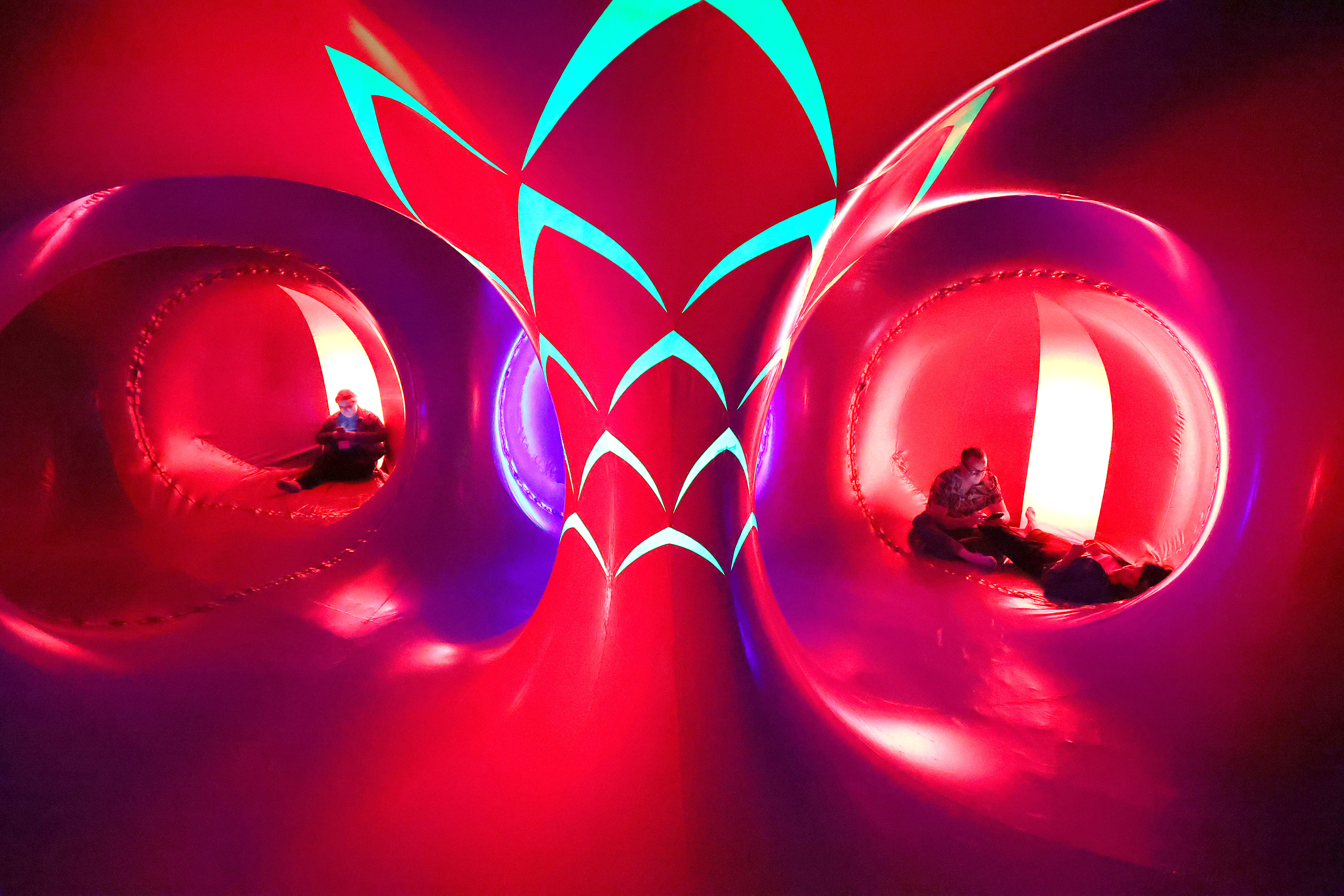 Attendees relax inside the Architects of Air Arborialis Luminarium during...