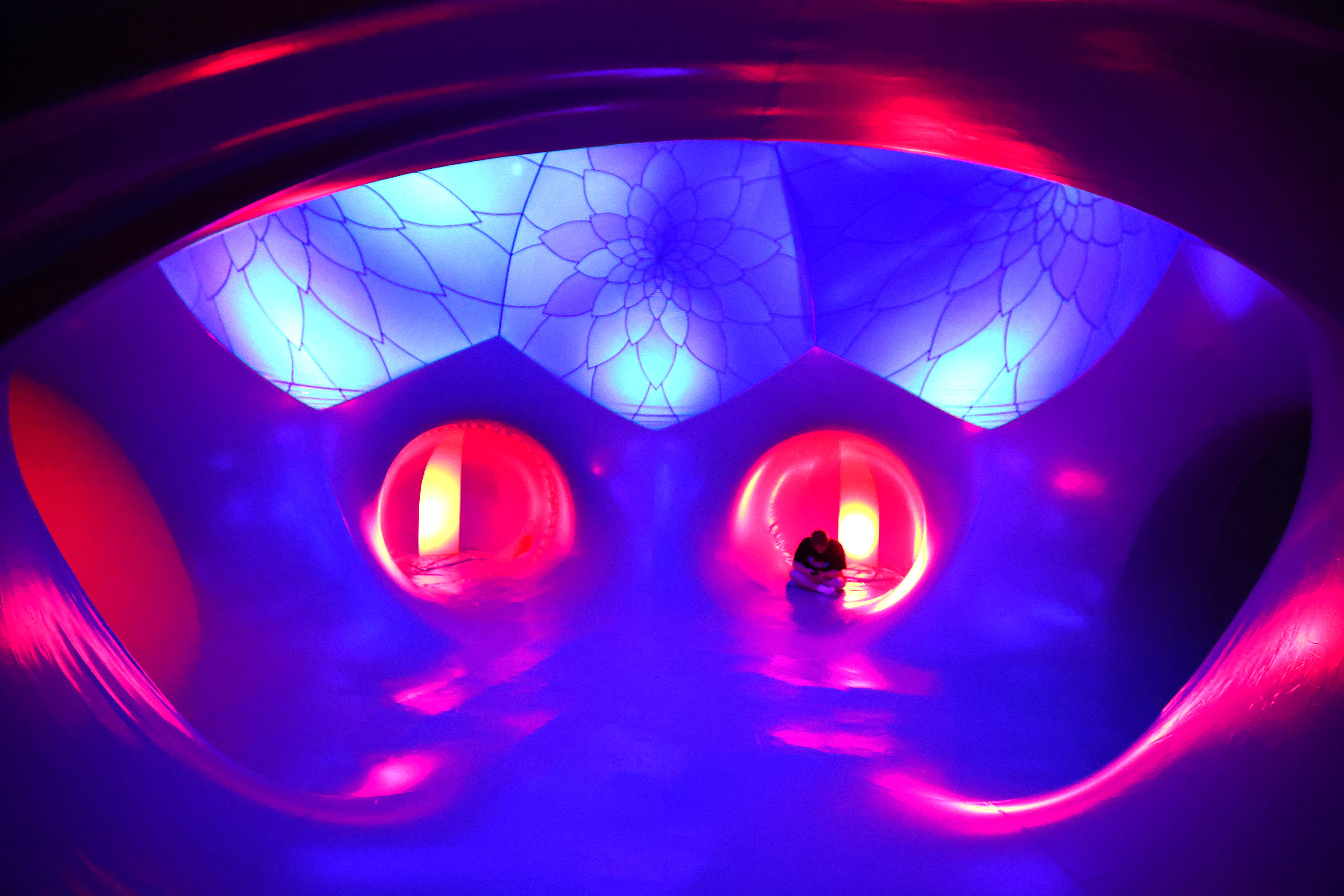 Attendees relax inside the Architects of Air Arborialis Luminarium during...