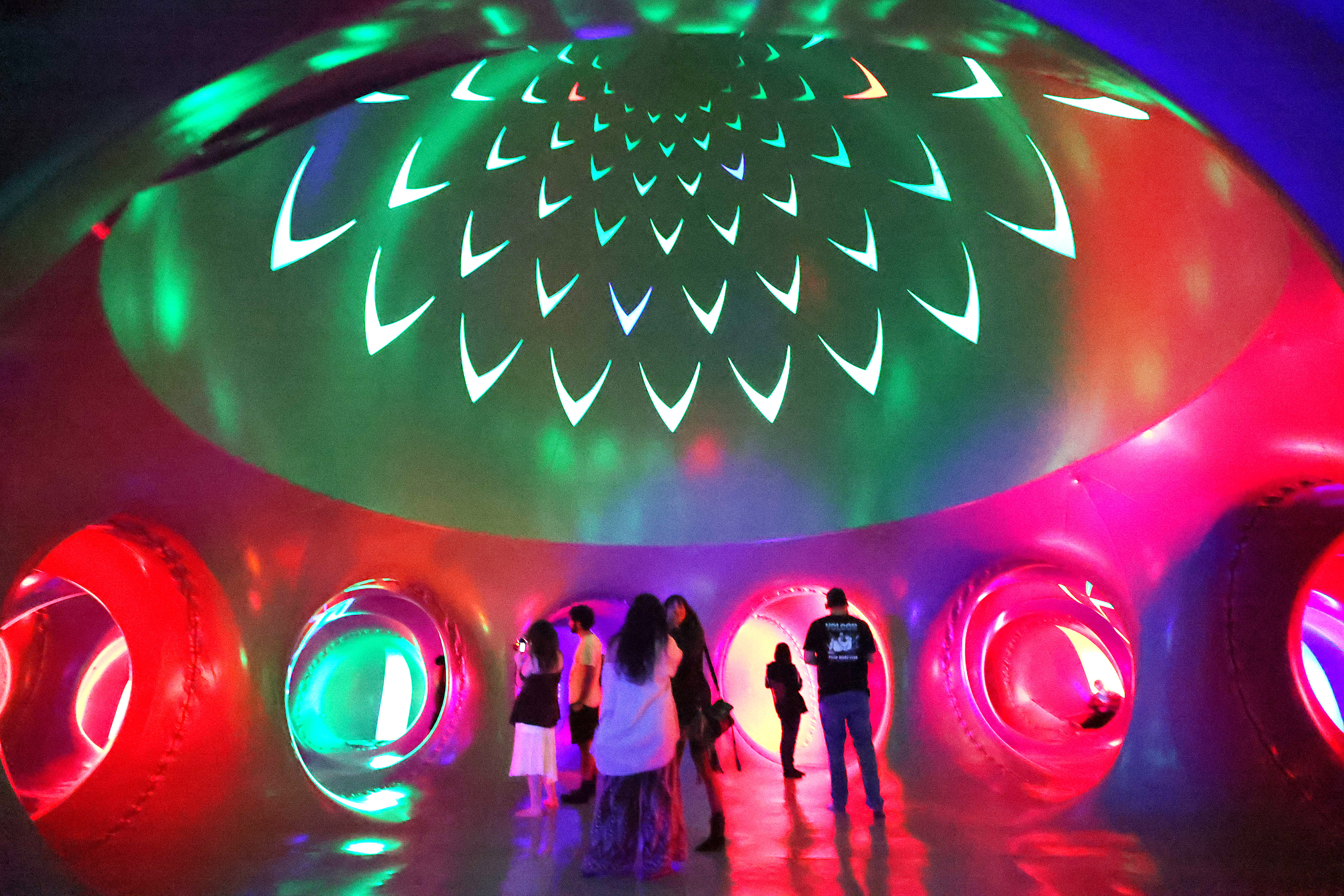 Attendees wander inside the Architects of Air Arborialis Luminarium during...
