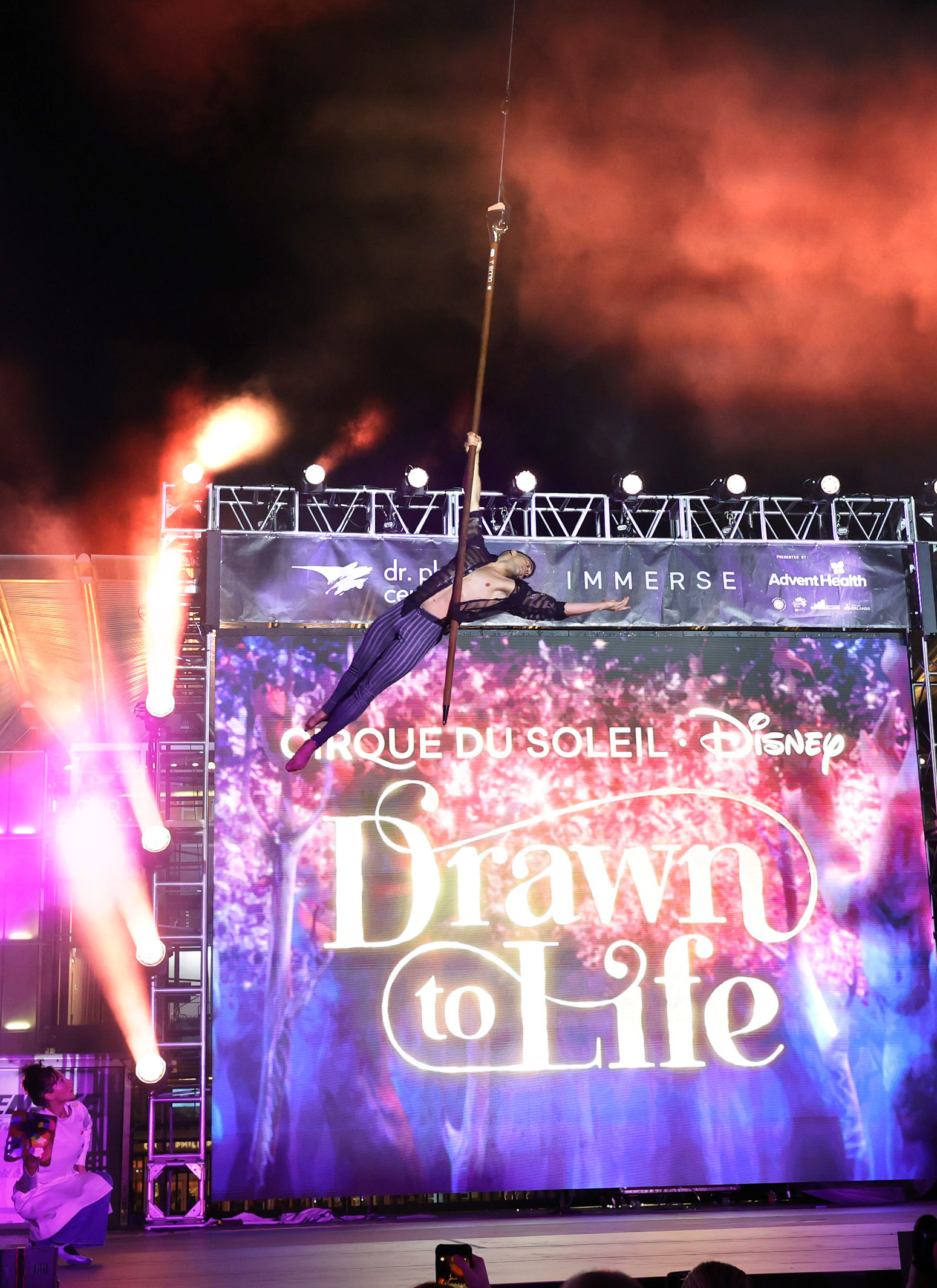 A Cirque du Soleil performer soars as he performs during...