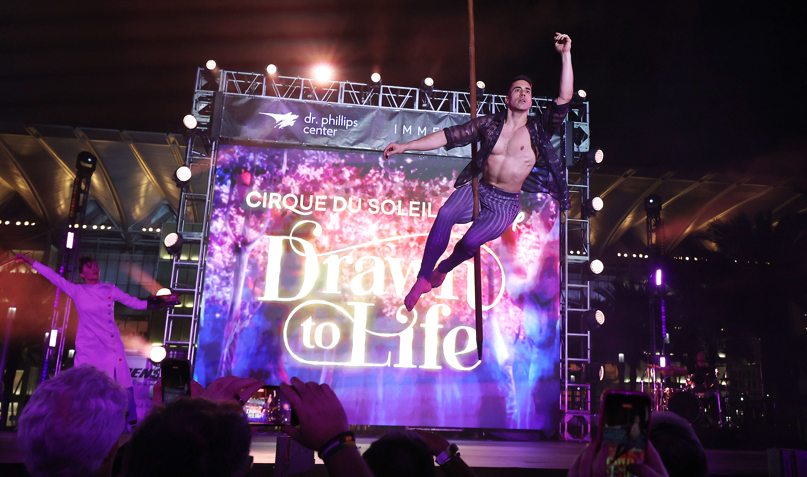 A Cirque du Soleil performer soars as he performs during...