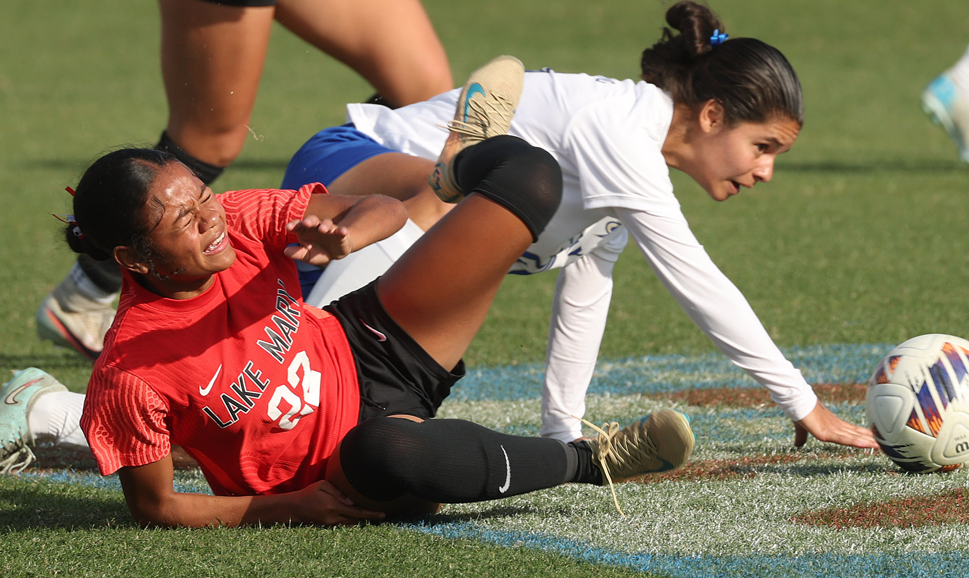 Lake Mary High player Jazmin Rentie (22) falls during the...
