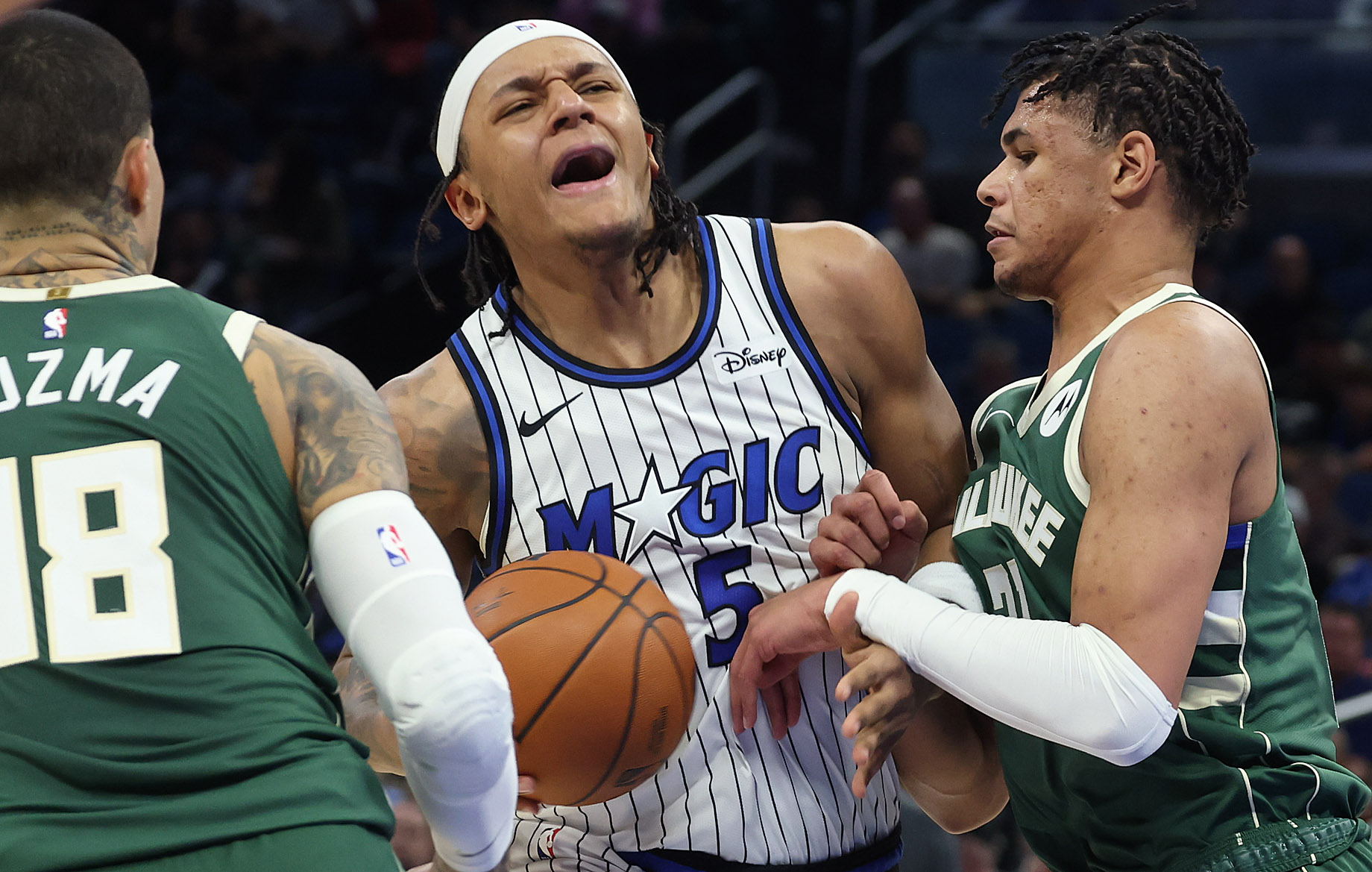 Orlando forward Paolo Banchero (5) tries to power through Milwaukee...