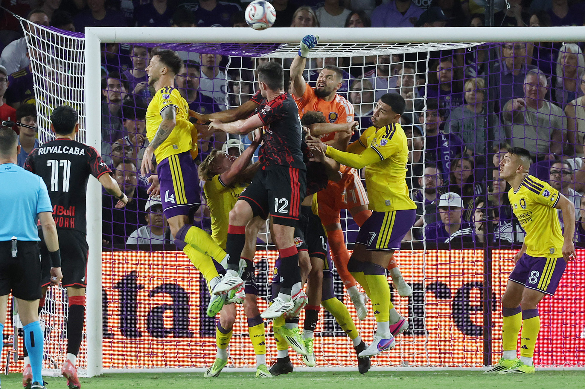 Orlando and New York players leap for a corner kick...