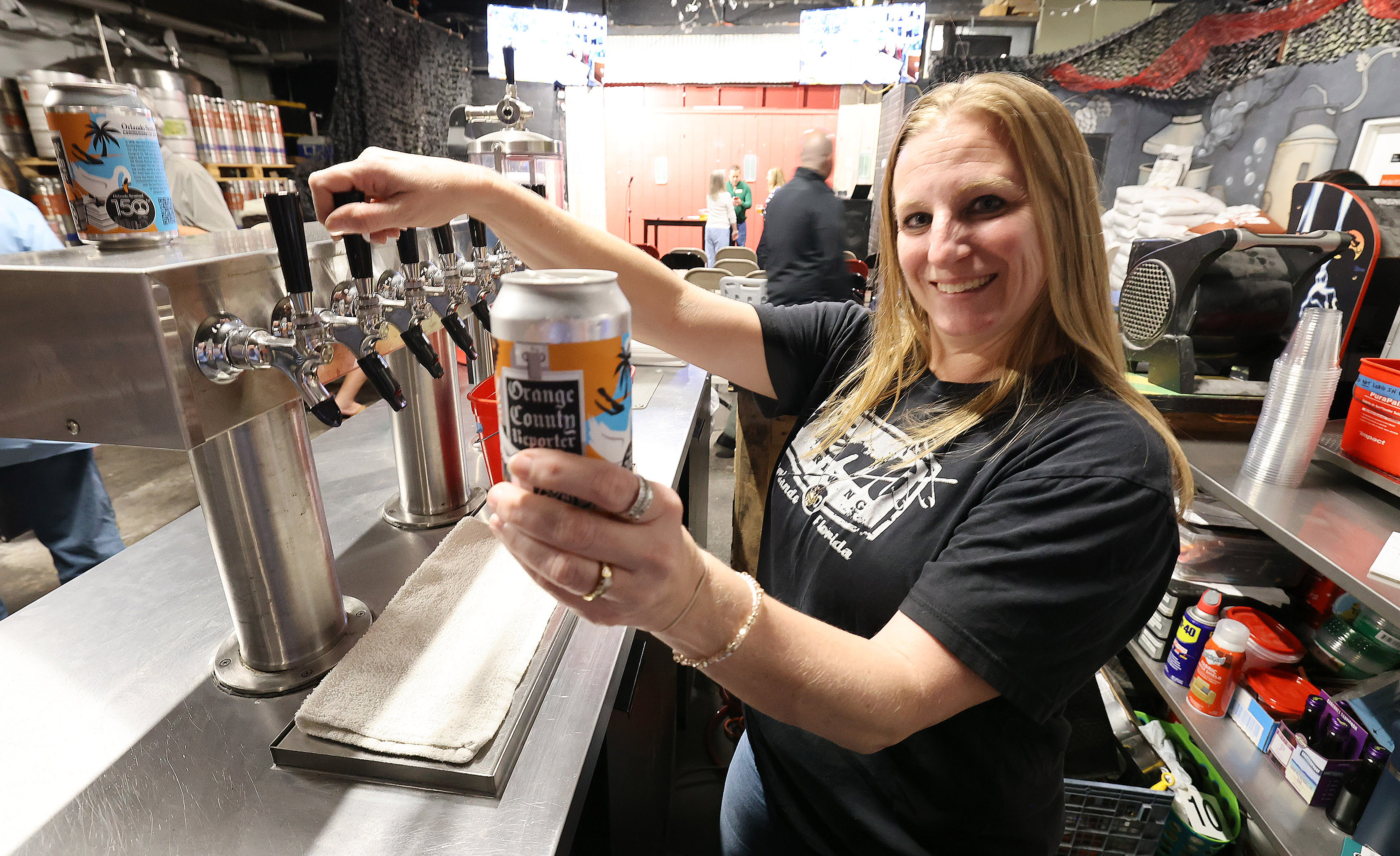 Michelle Wallace pours beer behind the bar during a gathering...