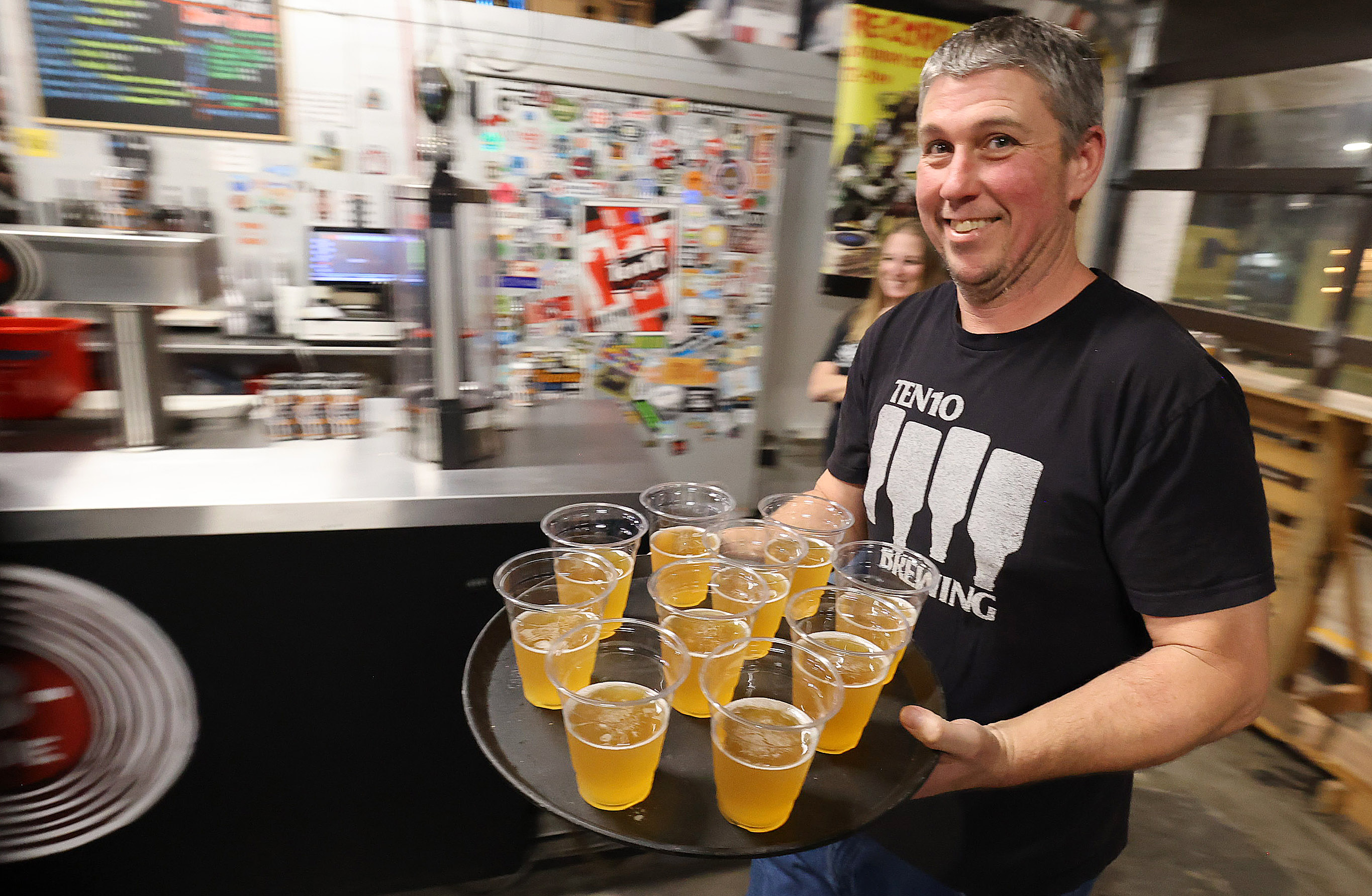 Ten10 Brewing owner Mike Wallace serves cold beer during a...
