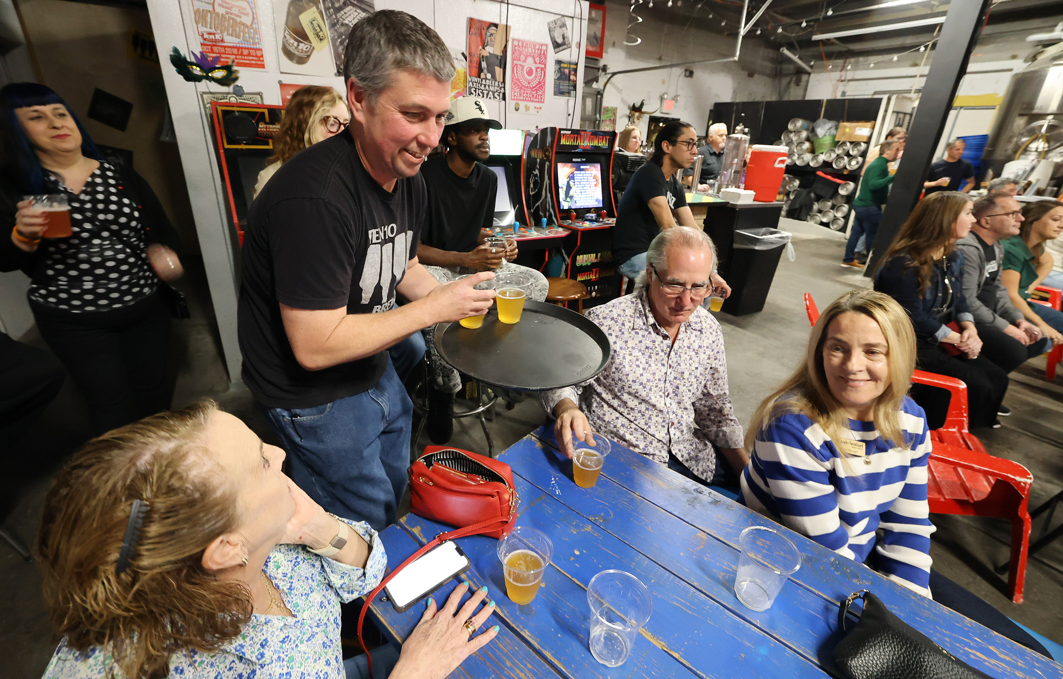 Ten10 Brewing owner Mike Wallace serves cold beer during a...