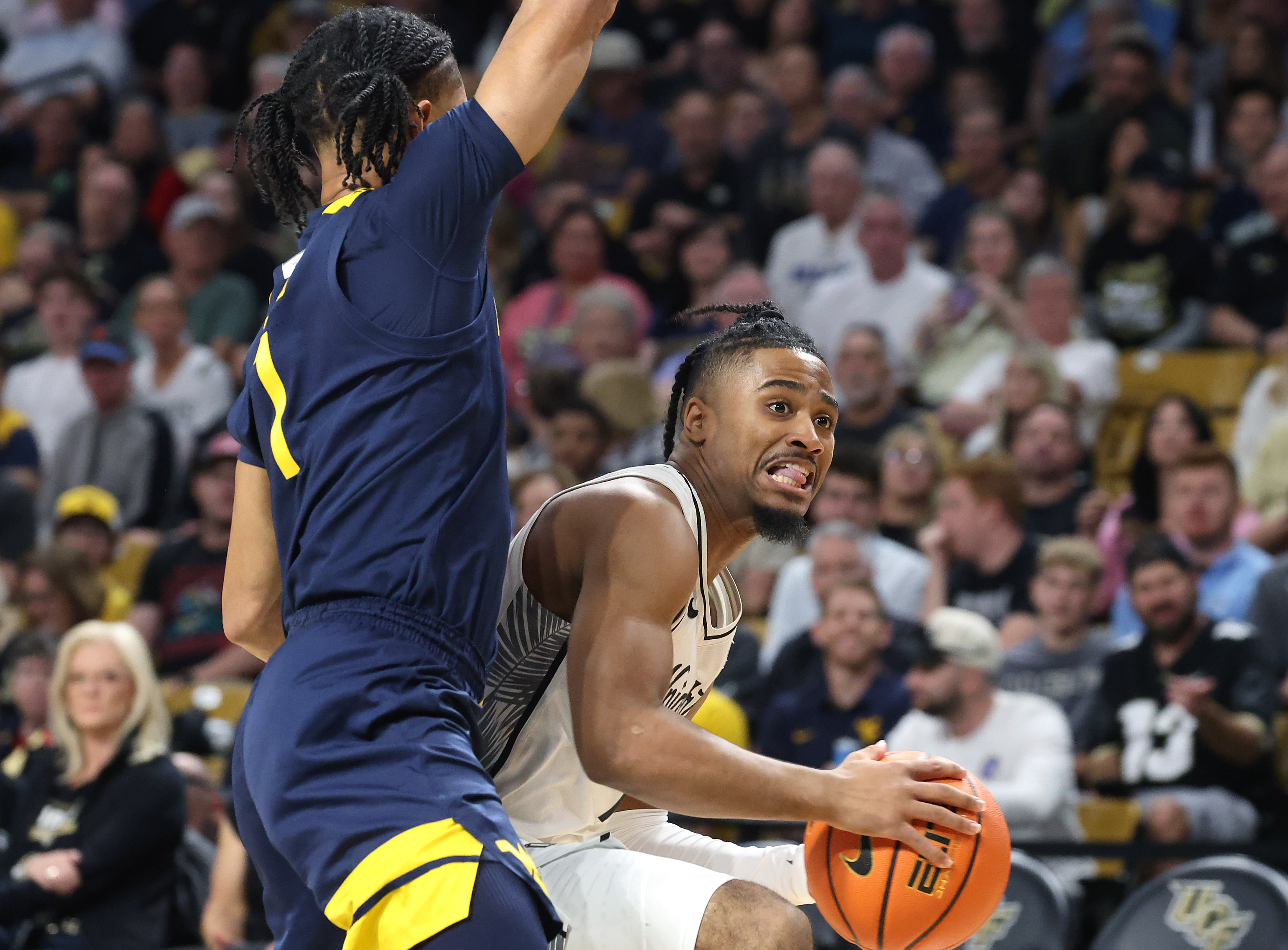 UCF guard Themus Fulks (right) works past West Virginia guard...