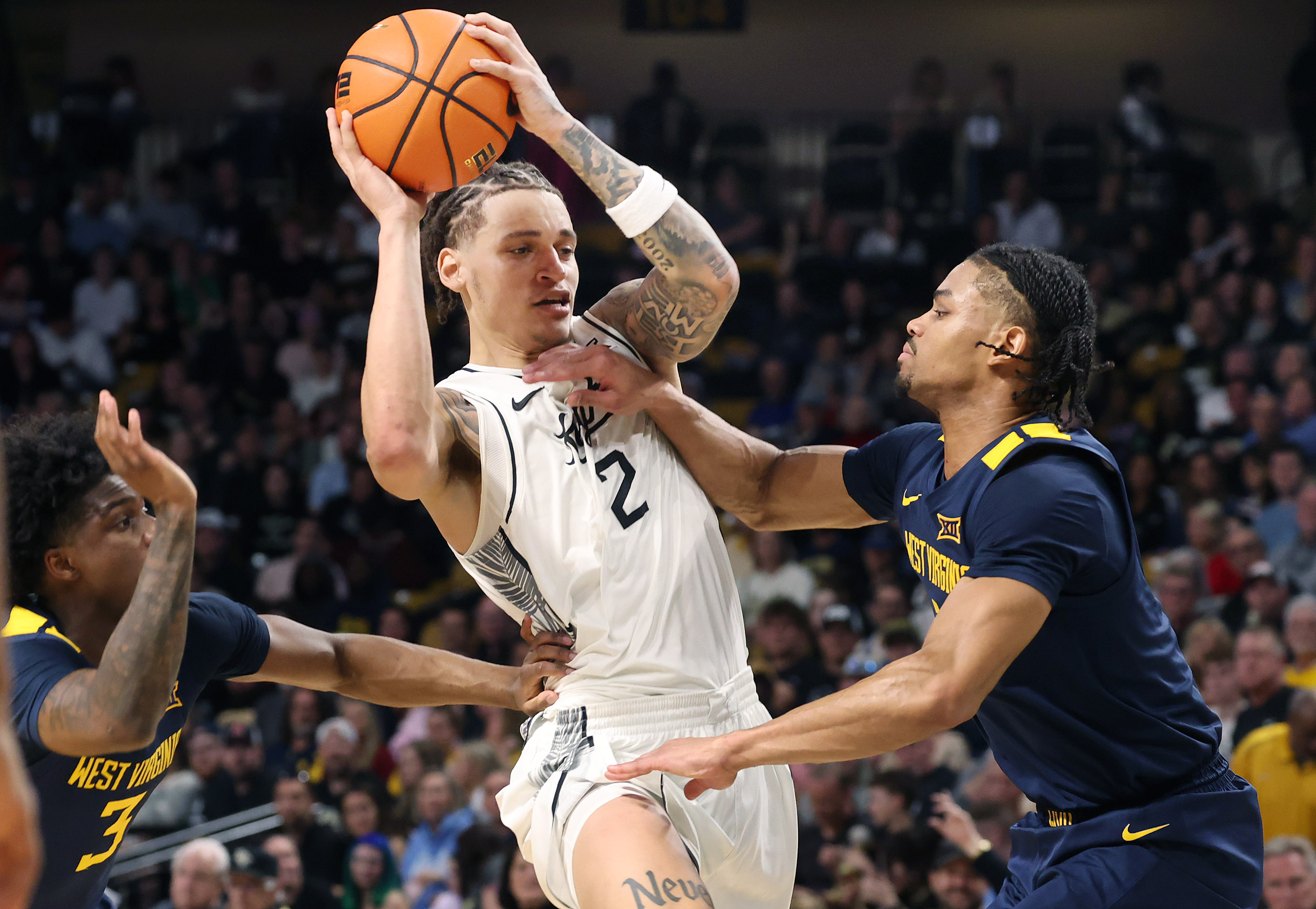 UCF guard Riley Kugel (2) works between West Virginia defenders...