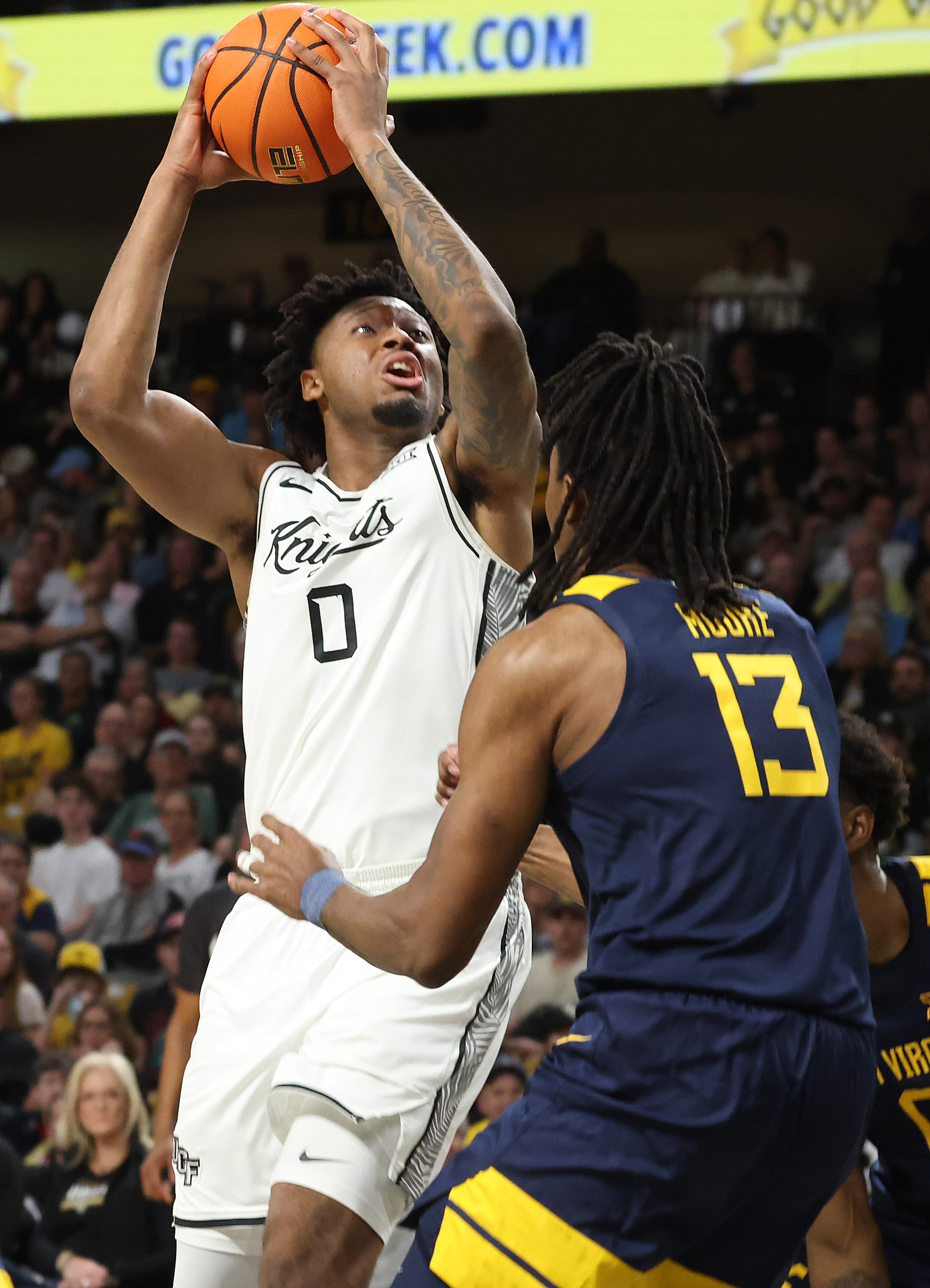 UCF center Jeremy Foumena (0) shoots over West Virginia guard...