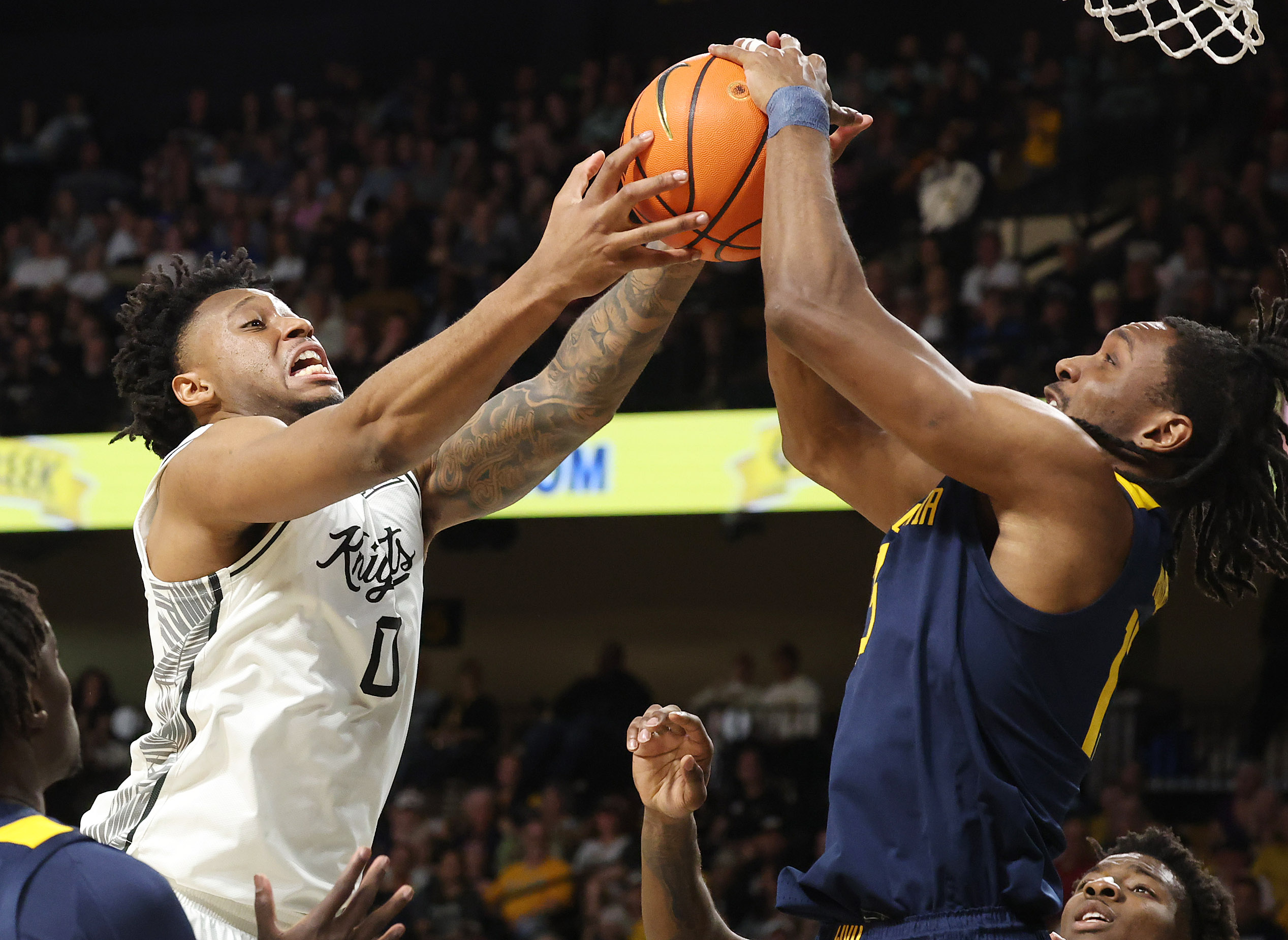 UCF center Jeremy Foumena (0) battles West Virginia guard Chance...