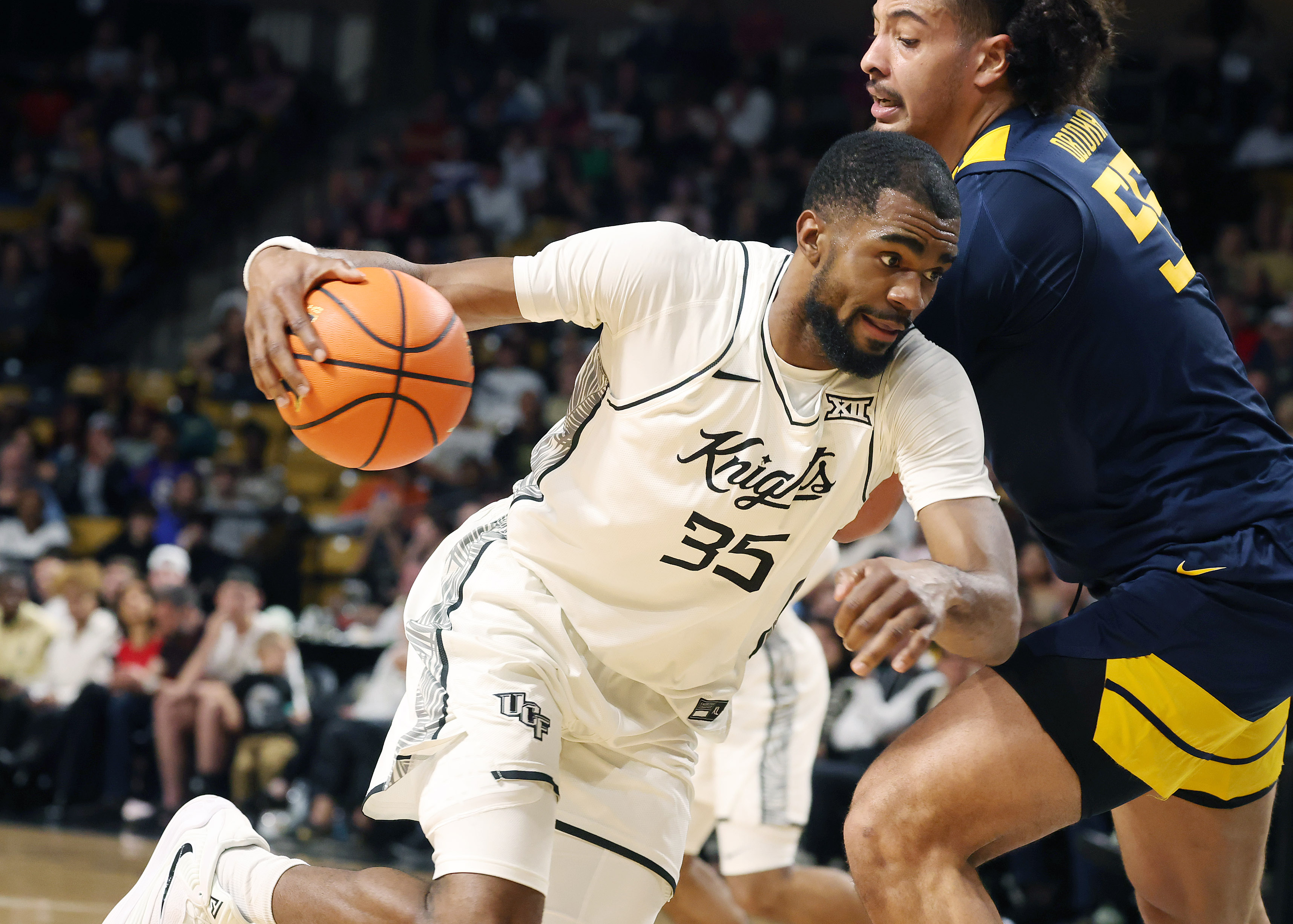 UCF forward Devan Cambridge (35) drives past West Virginia center...