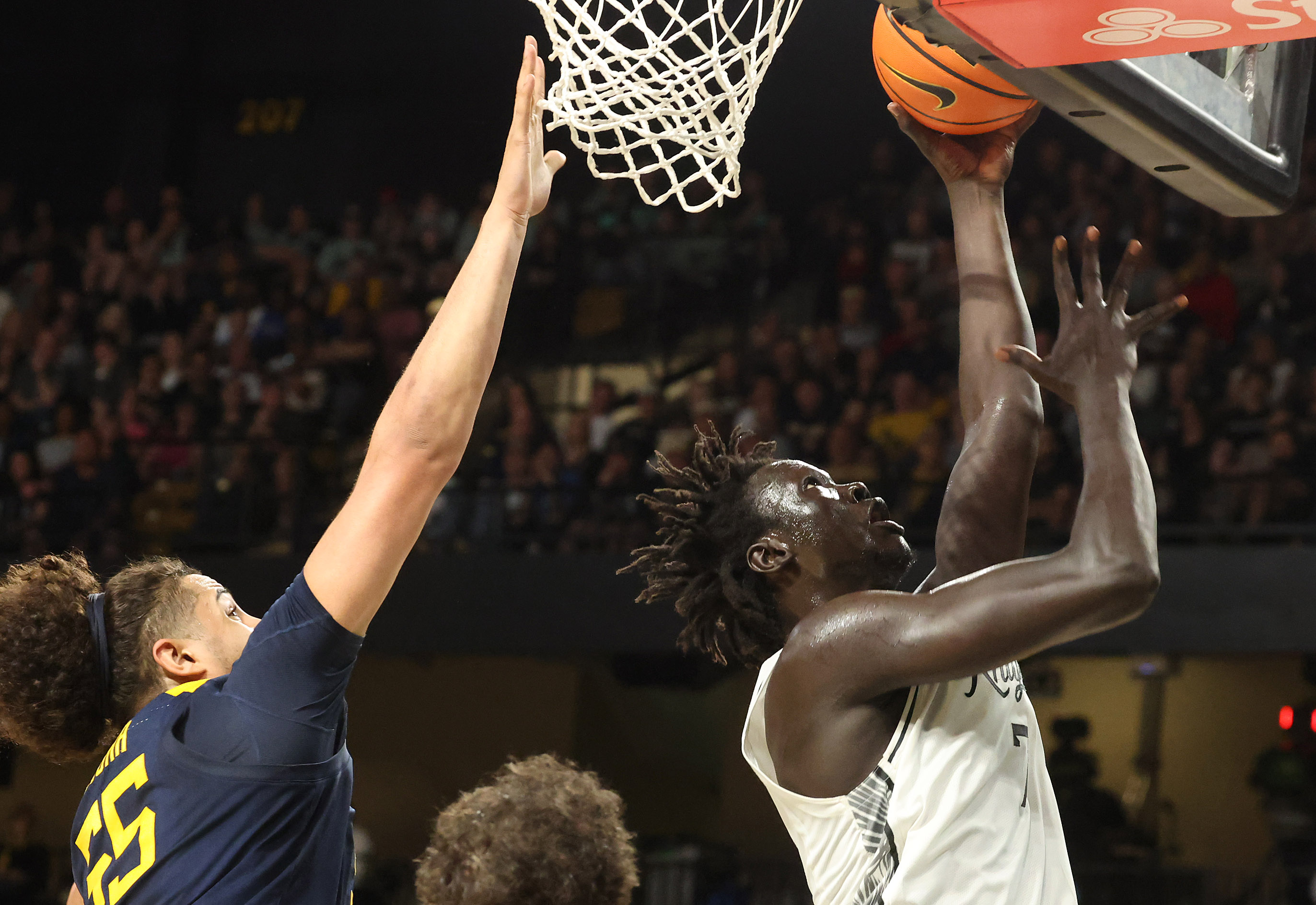 UCF center John Bol (right) scores past West Virginia center...