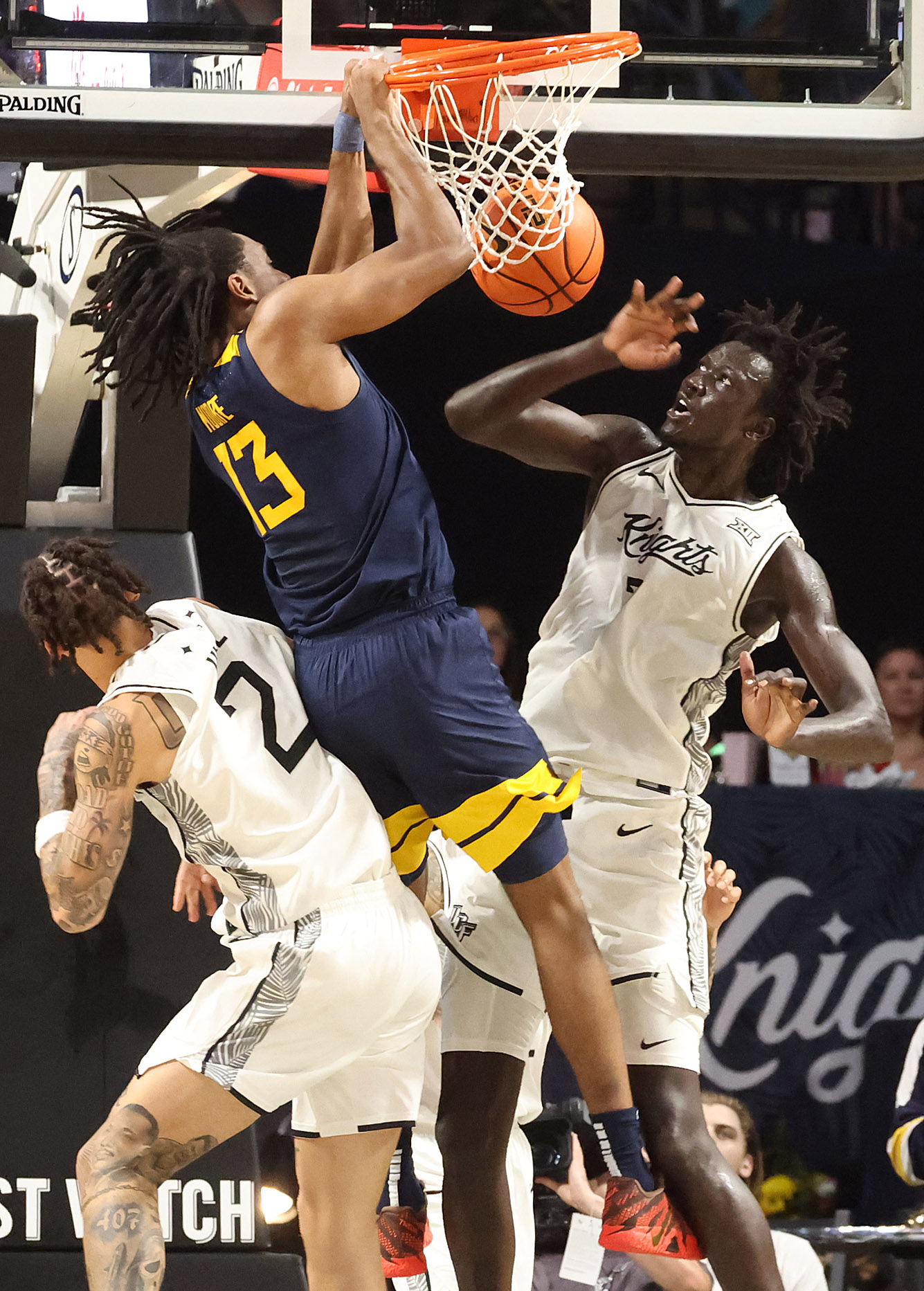 West Virginia Chance Moore (13) slam dunks over UCF center...