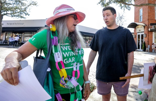 A representative from Three Birds Cafe, right, requests that Winter Garden resident Tess Nater and other demonstrators move further from their restaurant while protesting the restaurant's loss of their lease, Friday, Feb. 20, 2026. Local residents are expressing concern for the number of downtown small-business buildings that have been purchased by a commercial real estate entity recently. (Joe Burbank/Orlando Sentinel)