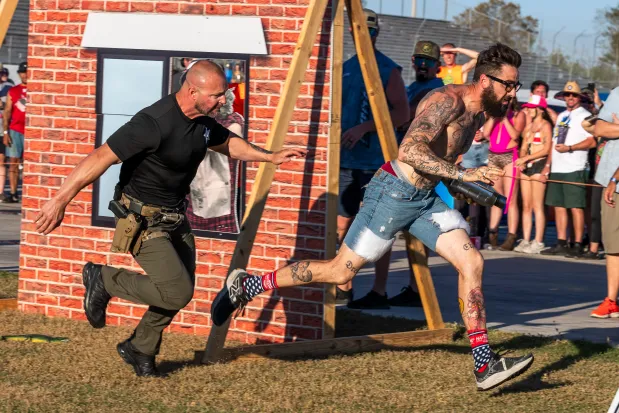 A competitor runs from a member of the Manatee County Sheriff's Office SWAT team during the Florida Man Games at the Freedom Factory in Bradenton on Feb. 21, 2026. (Patrick Connolly/Orlando Sentinel)