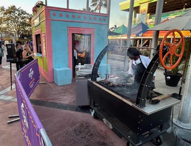 Universal Studios employees operate a Brazil-themed kiosk during Mardi Gras celebration at the theme park. (Dewayne Bevil/Orlando Sentinel)