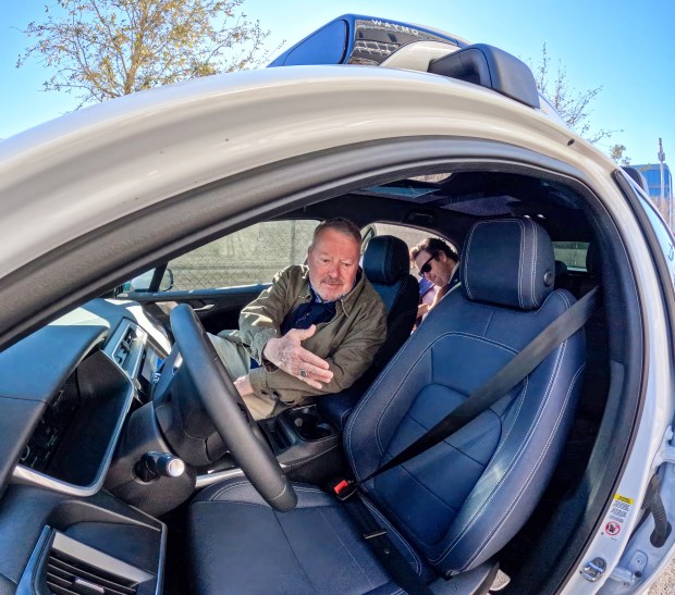 Orlando mayor Buddy Dyer and Waymo southeast policy manager John Tupps, right, prepare to ride in the fully-autonomous robotaxi vehicle to on the first official day of service in Orlando, Tuesday, Feb. 24, 2026. Orlando joined Dallas, Houston and San Antonio with the Waymo service debut on Tuesday, bringing the total to 10 U.S. cities that have the driverless ride-hailing service. (Joe Burbank/Orlando Sentinel)