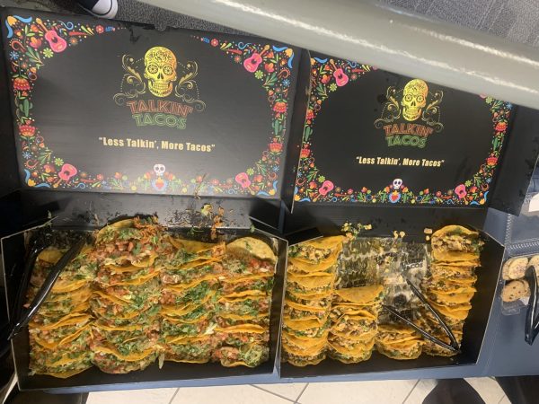 Black cabinet filled with tacos. The Talks with Tacos logo is on the top.