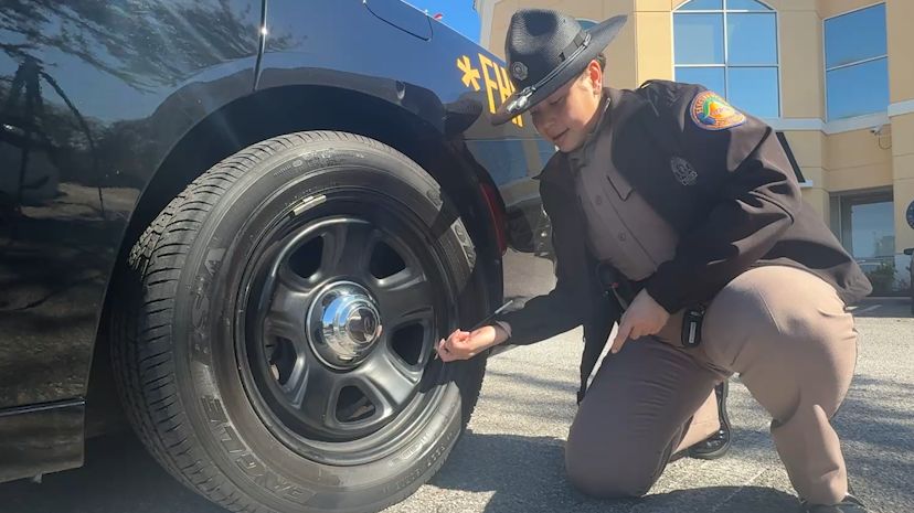 Trooper Migdalisis Garcia, Florida Highway Patrol, checking the air pressure on her vehicle. (Spectrum News/Kiara Velez)