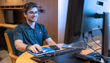 Velocity IQ employee and SPC graduate Theo Varitimidis sits at his computer