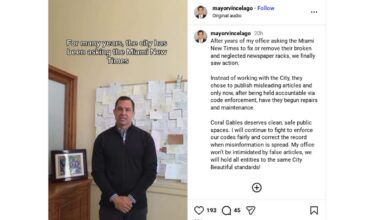 Screenshot of Coral Gables Mayor Vince Lago's video where he is standing in his office wearing a quarter zip and his hands folded in front of him.