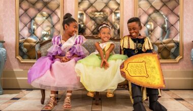Three smiling kids in princess and knight costumes sit on a bench, echoing the royal flair of a Disney Park&rsquo;s castle interior.
