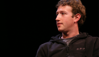 Mark Zuckerberg looks away from the camera while wearing a black half zip