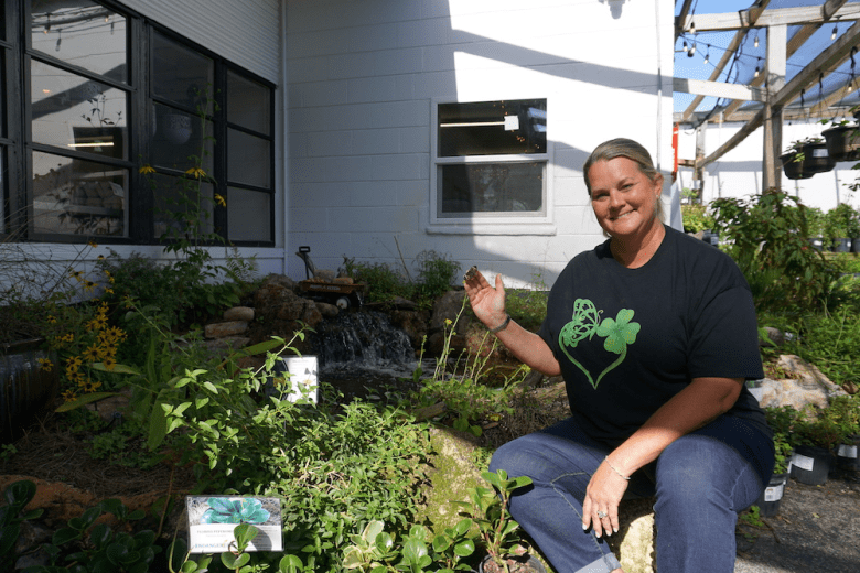 Anita Camacho poses with her butterfly garden.