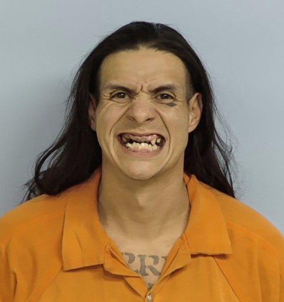 Mugshot of Blackie Alvarez, 33, from Bonifay, Florida, with long dark hair, wearing an orange jail uniform, and baring his teeth.