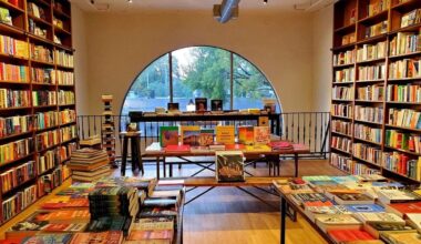 the inside of a bookstore with an arched doorway leading to book lined shelves on either side of a light filled room