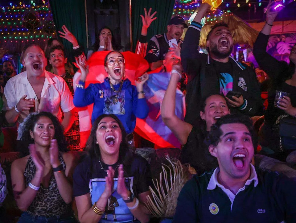 In the center, Tara Fougner, screams along with others while waving a Puerto Rican flag as Bad Bunny starts his show. 