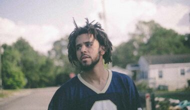 Photo of a man with curly hair outside in a neighborhood with trees