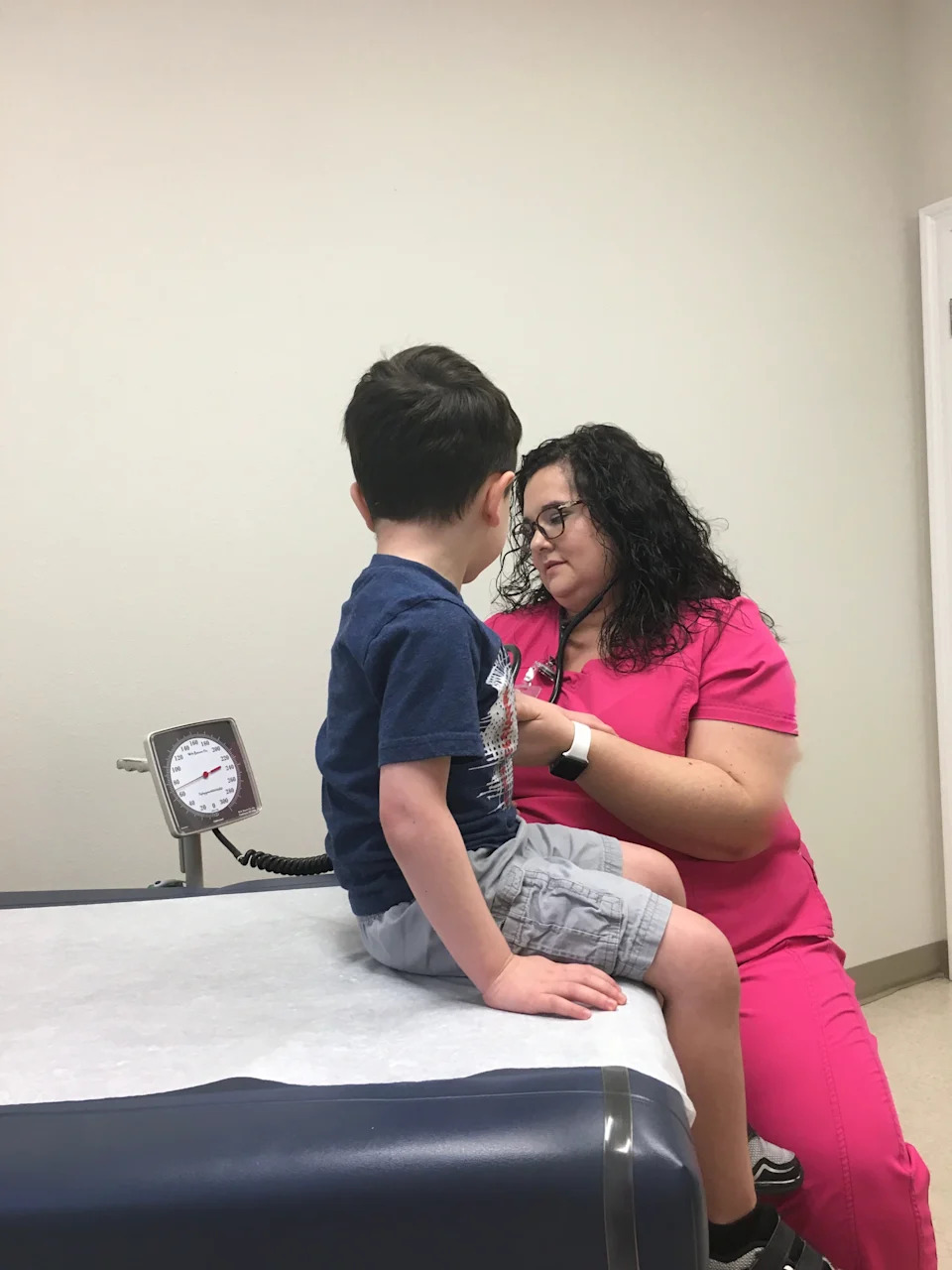 Rebekah Slack, DNP(c), BSN, RN with son, Micah Slack in 2019 checking blood pressure at his yearly well child exam.