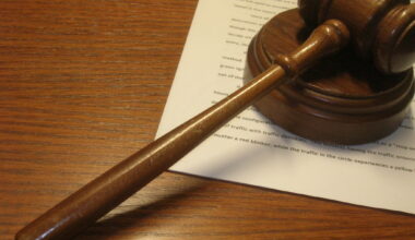 a wooden gavel on a wooden desk on top of some legal paperwork