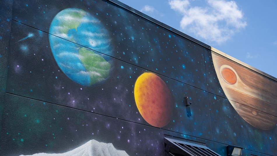 mural of planets in our solar system on the side of a building on the Gibbs Campus