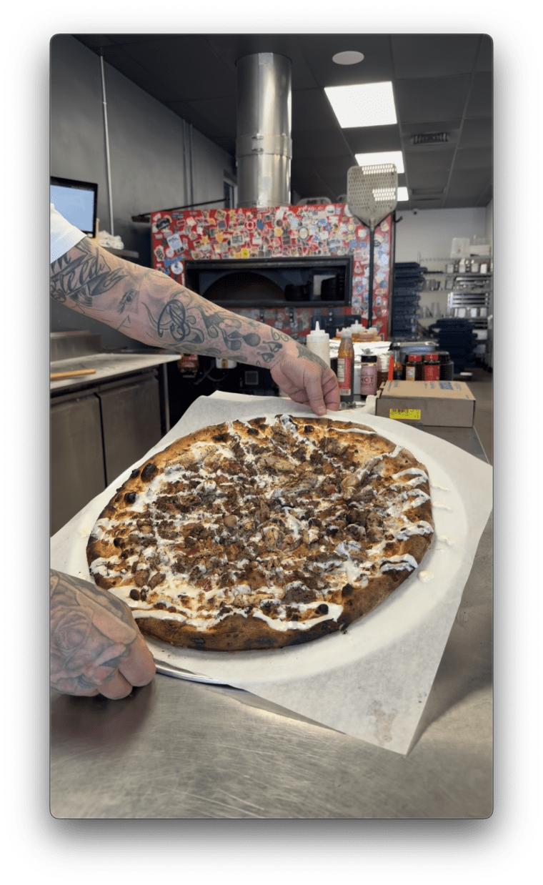 Frankie Cecere shows off his iguana pizza.